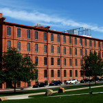 Brick building on a sunny day, con trails in the sky.